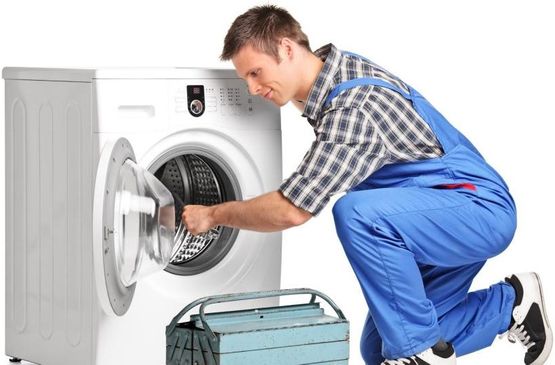 Tekniker reparerer en vaskemaskin